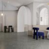 Paris Terrazzo 场景应用 - 1200x1200mm哑光深灰色水磨石瓷砖艺术感公共空间, 灰色基底带白色浅灰颗粒点缀, 哑光面沉稳自然无眩光, 拱门弧形元素现代简约北欧风格, Contigo Ceramics佛山工厂